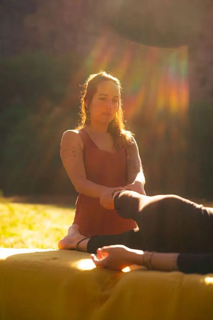 Isabel Maler pratiquant une libération fasciale sur le pied lors d'une formation en plein air